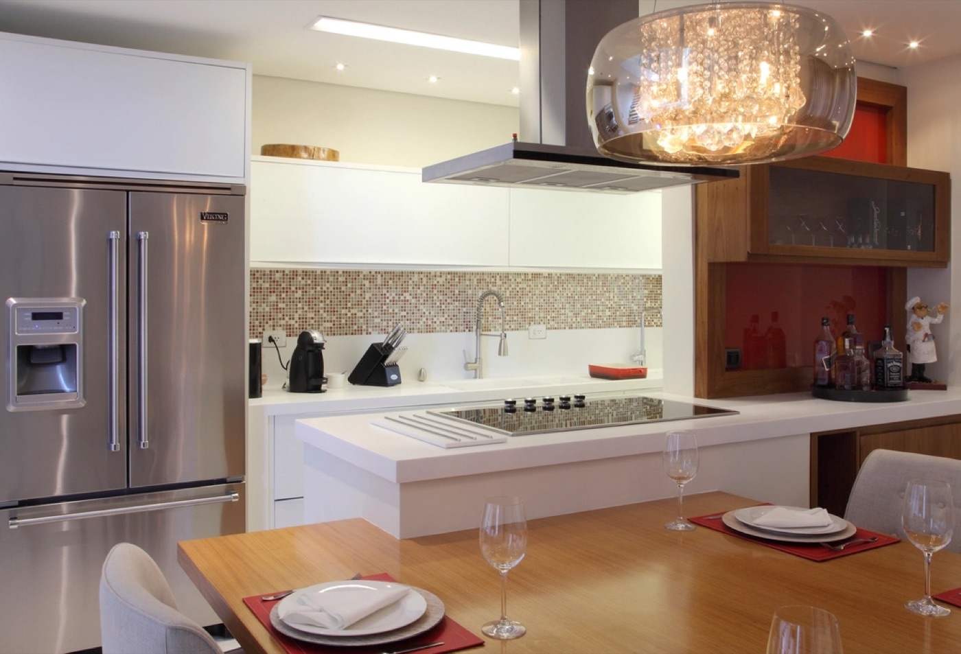 Bright modern kitchen with a dining table set for dinner and an island counter.